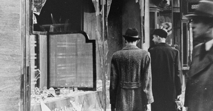 Ciudadanos alemanes al día siguiente de la noche de los cristales rotos, frente a tiendas y casas judías destruidas (National Archives and Records Administration, College Park)