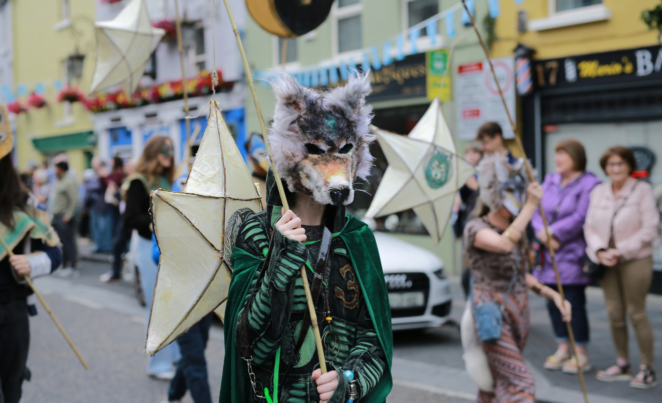 Una persona con máscara de lobo durante una celebración en la calle (Unsplash/Marina Nazina)